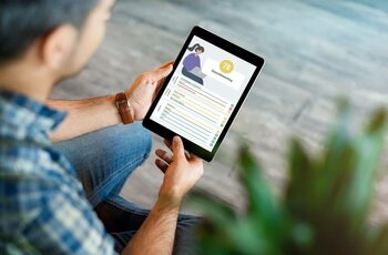 Eine Person hält ein Tablet mit einer Benutzeroberfläche, die Daten und eine Gesamtbewertung anzeigt.